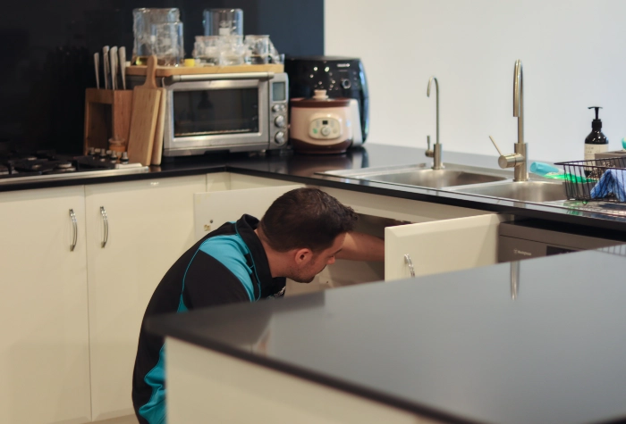 Plumber inspecting a blocked drain in a domestic plumbing job